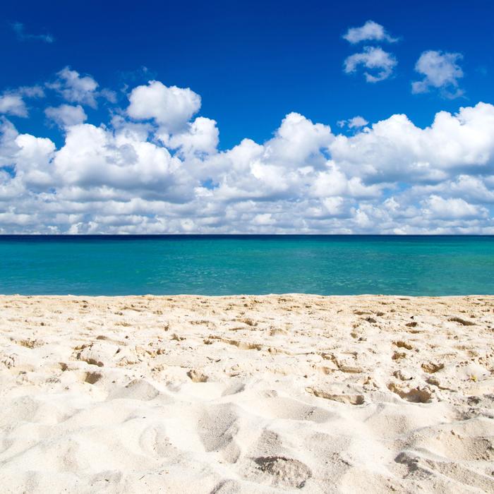 White sand under a sky of big clouds
